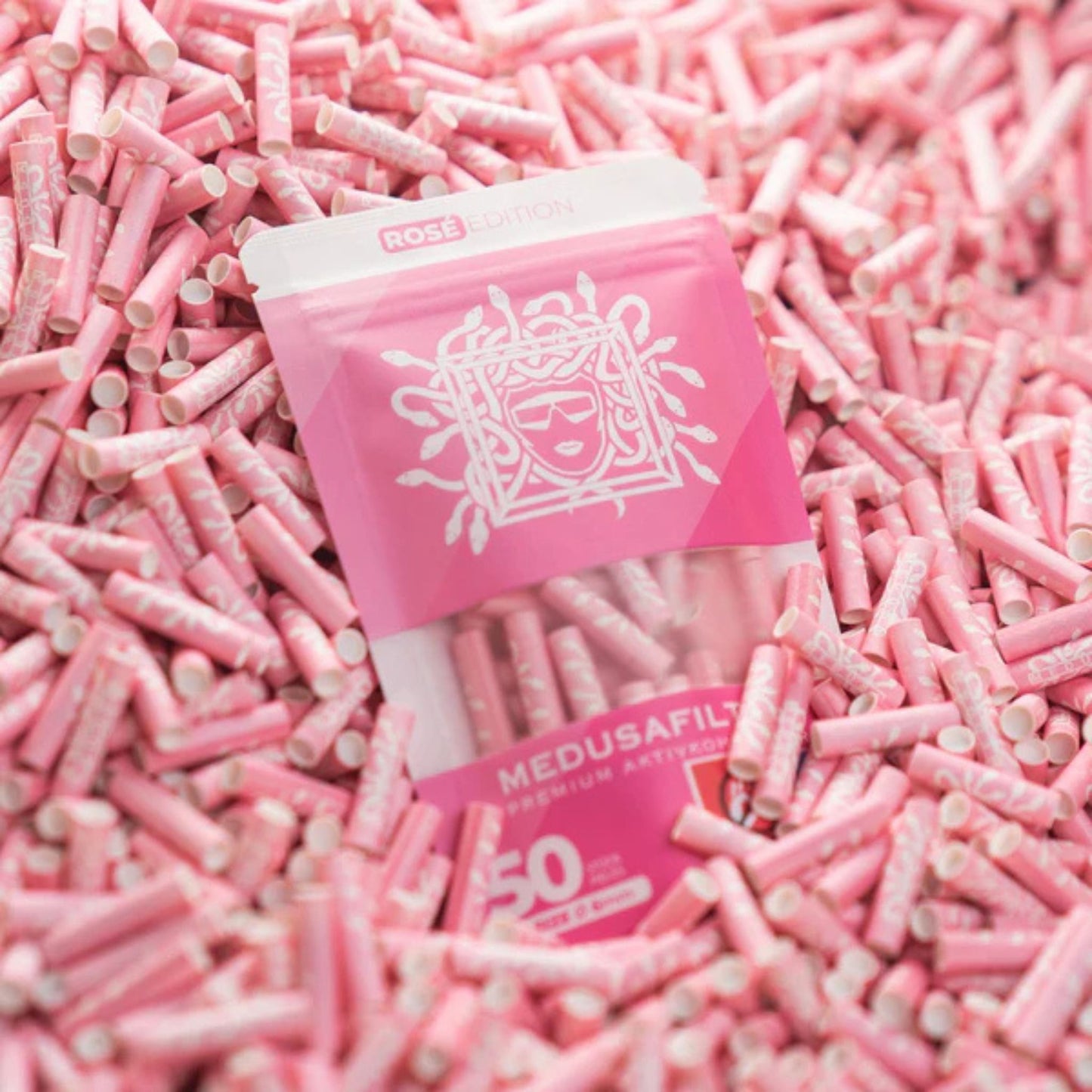 Rosafarbener Aktivkohlefilter mit Aufschrift "MEDUSAFILTERS" und "HOCHWERTIGE KOKOSNUSS AKTIVKOHLE" in rosa.