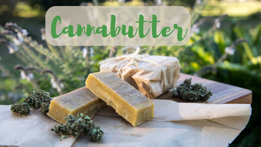 Selbstgemachte Cannabutter in einer Schale, umgeben von frischen Cannabisblättern und Backutensilien – die Basis für kreative Rezepte.