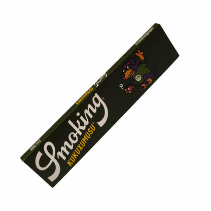 Smoking Kukuxumusu Longpapers mit schwarzem Design und Cartoon-Hund mit Peace-Zeichen, schräg fotografiert auf weißem Hintergrund